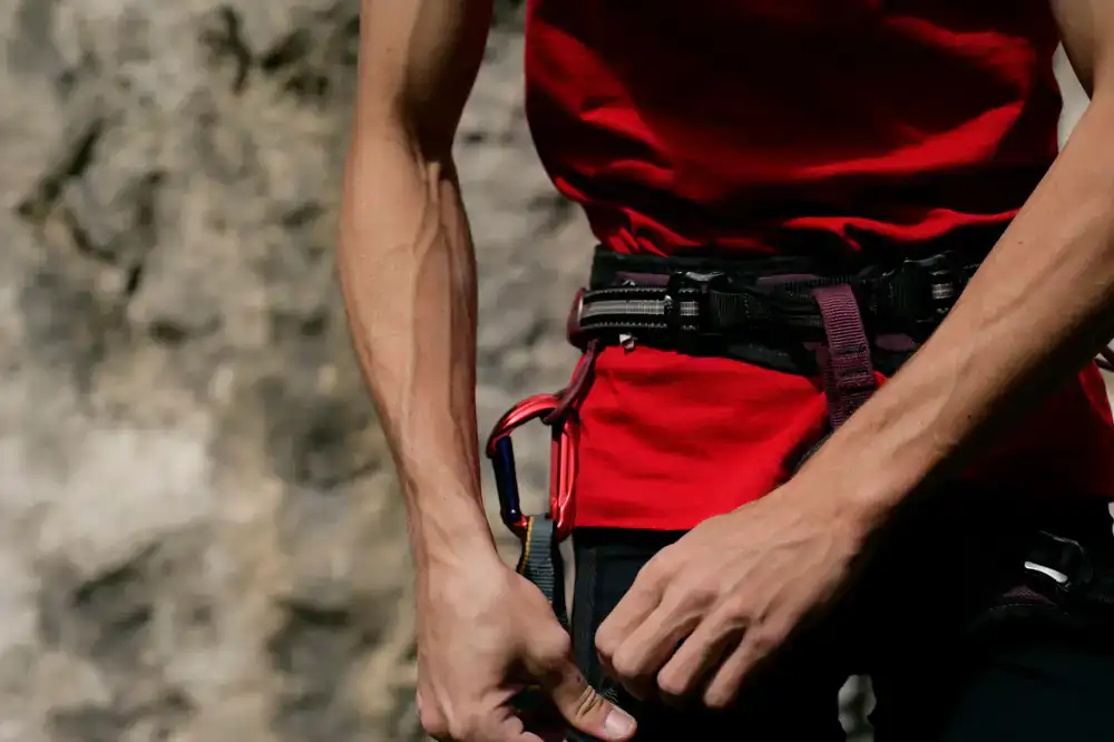 Climber on a sheer rock face preparing their equipment